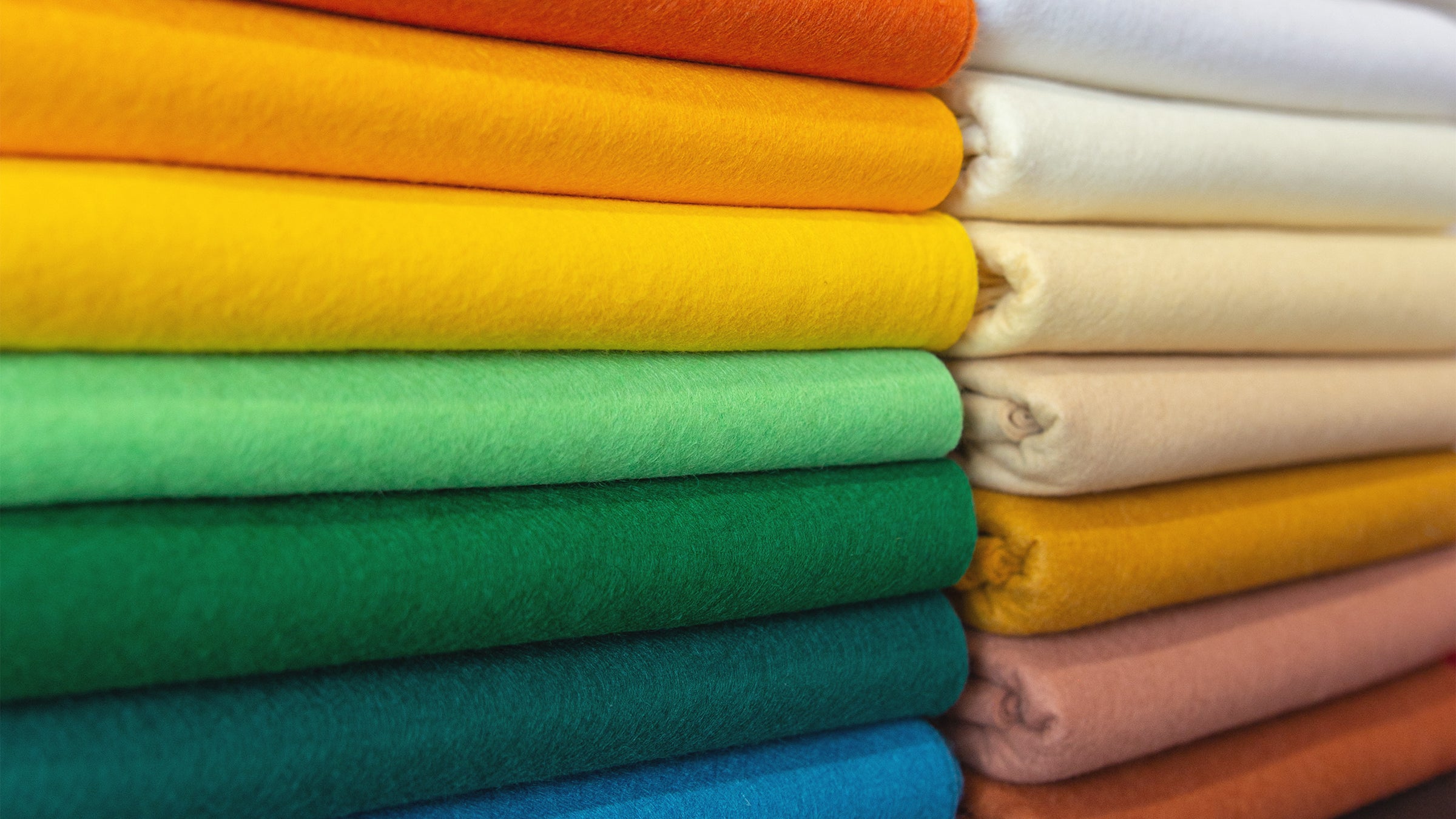 Stack of The Felt Store's vibrant colored Premium Wool Blend half yard pre-cut felt sheets 